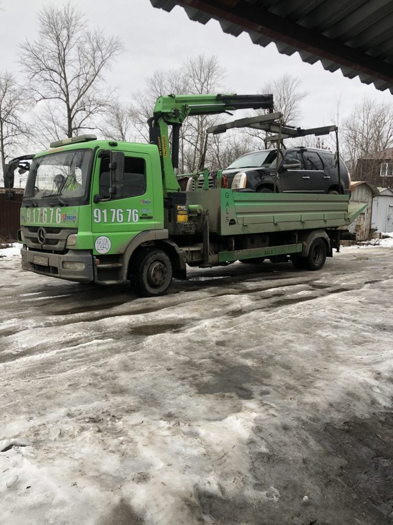 Эвакуатор с манипулятором перевозит Cadillaс Escalade по Ярославлю