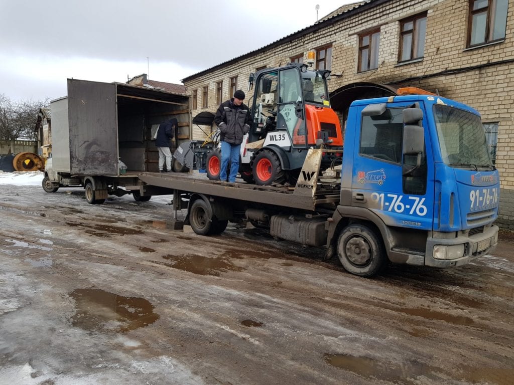Эвакуатор загружает погрузчик в газель