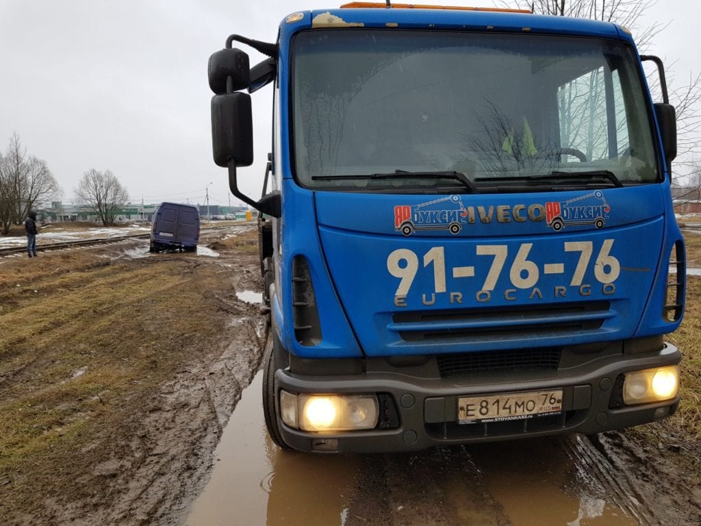 Эвакуатор и застрявший на грунтовой дороге фургон Газель